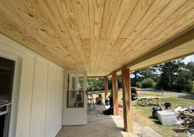 A wooden porch featuring a sturdy railing and a window, showcasing a rustic and inviting outdoor space.