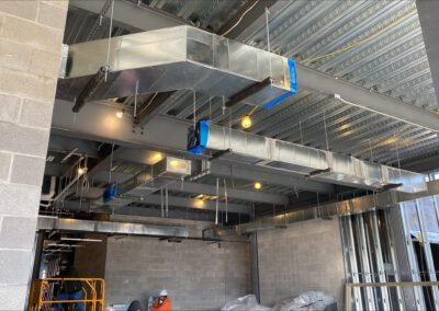 Industrial HVAC ductwork installation in a building under construction.
